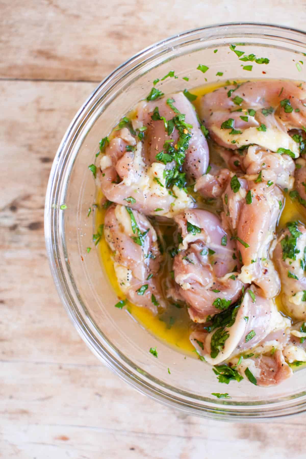 lemon chicken marinade poured over raw chicken.