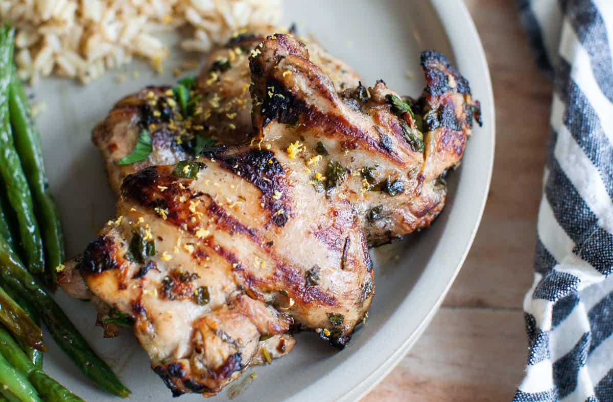 grilled chicken thighs with fresh parsley on a plate