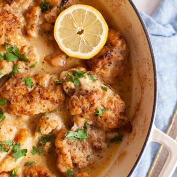 lemons, parsley and chicken in a white pan.