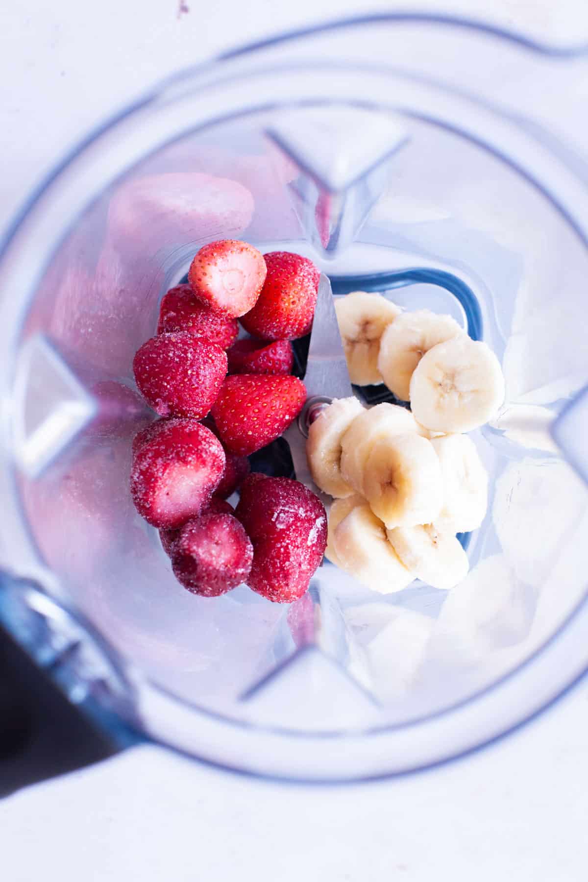 Frozen strawberries and banana slices in blender.