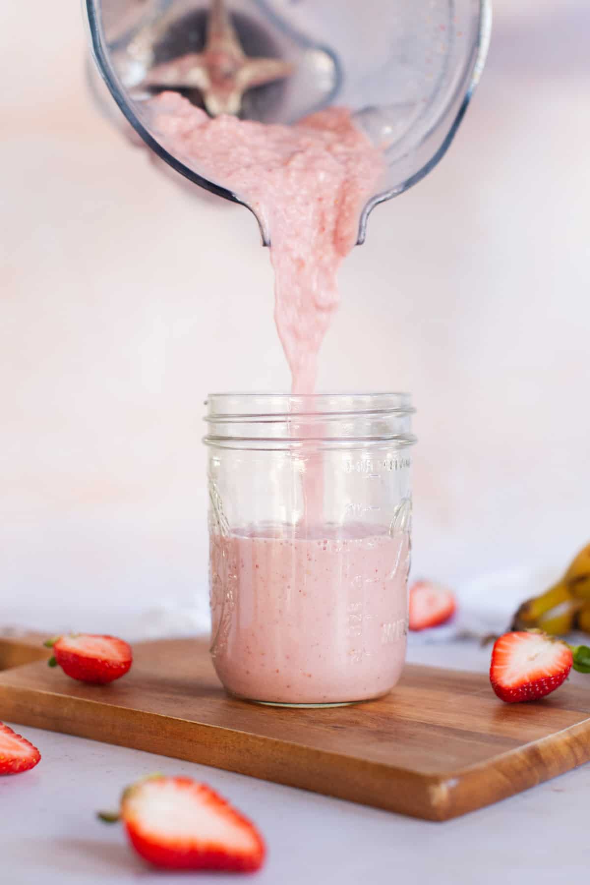 Smoothie pouring into glass jar.