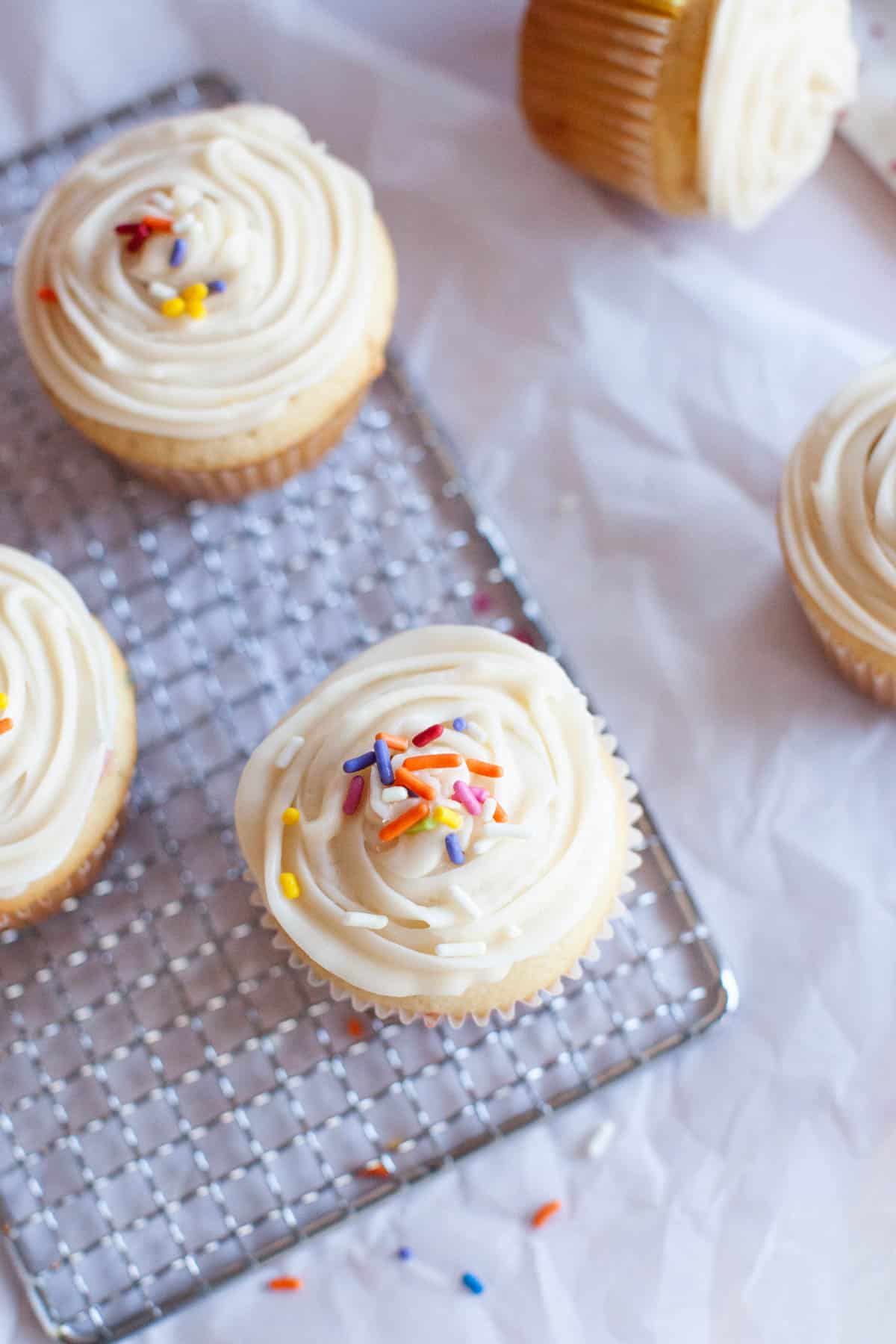 sprinkles rest atop a batch of confetti cupcakes.