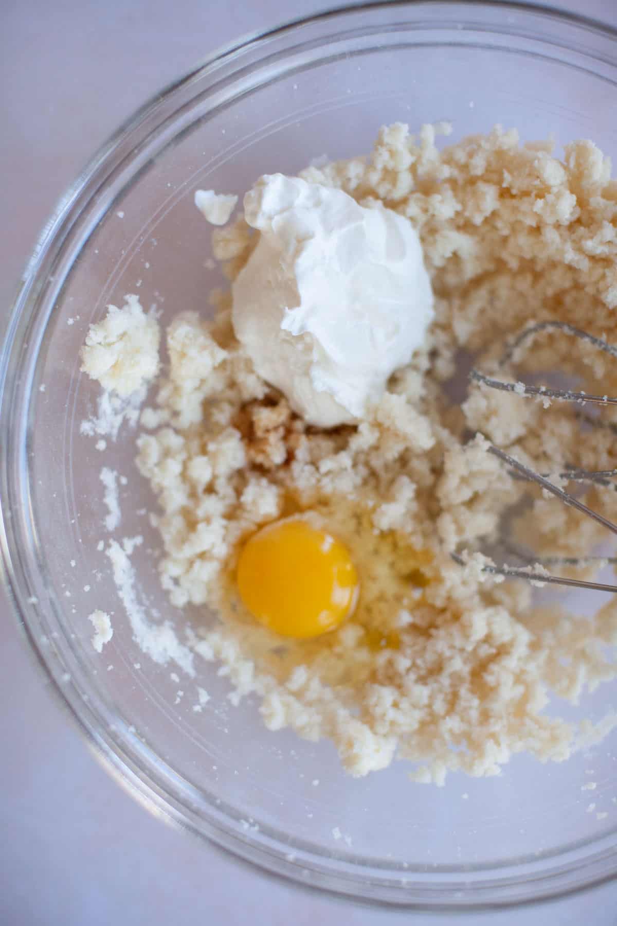 an egg and sour cream mixing into the batter.