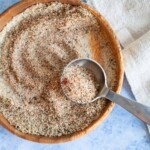 A wooden bowl of bbq chicken rub with a metal tablespoon sitting in it.