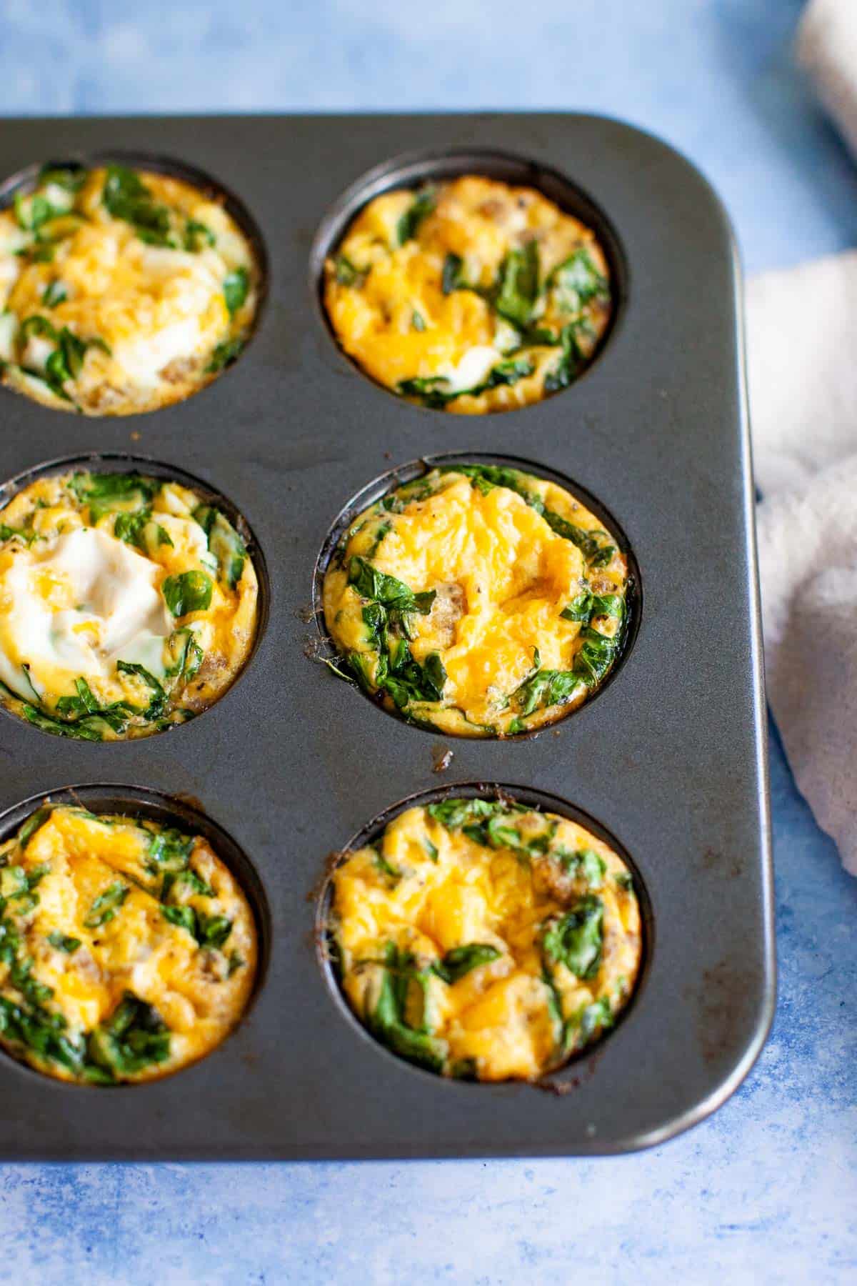 Baked breakfast egg muffins in a muffin tin.