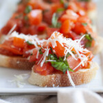 Close-up photo of pieces of bruschetta on a rectangular serving dish.