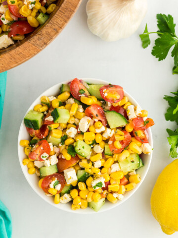 Corn salad mixed together in a white bowl.