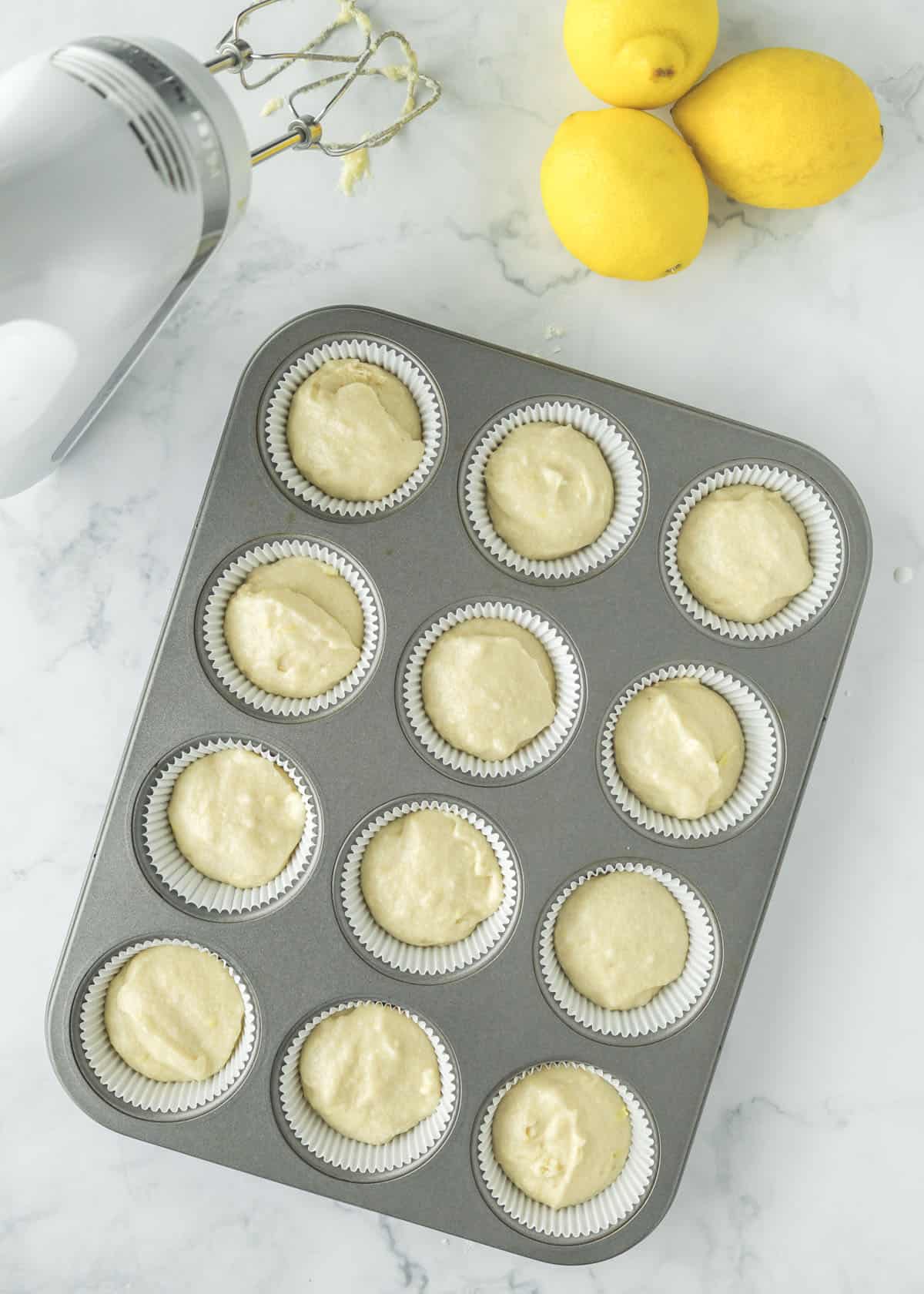 Completed cupcake batter poured into lined muffin tin.