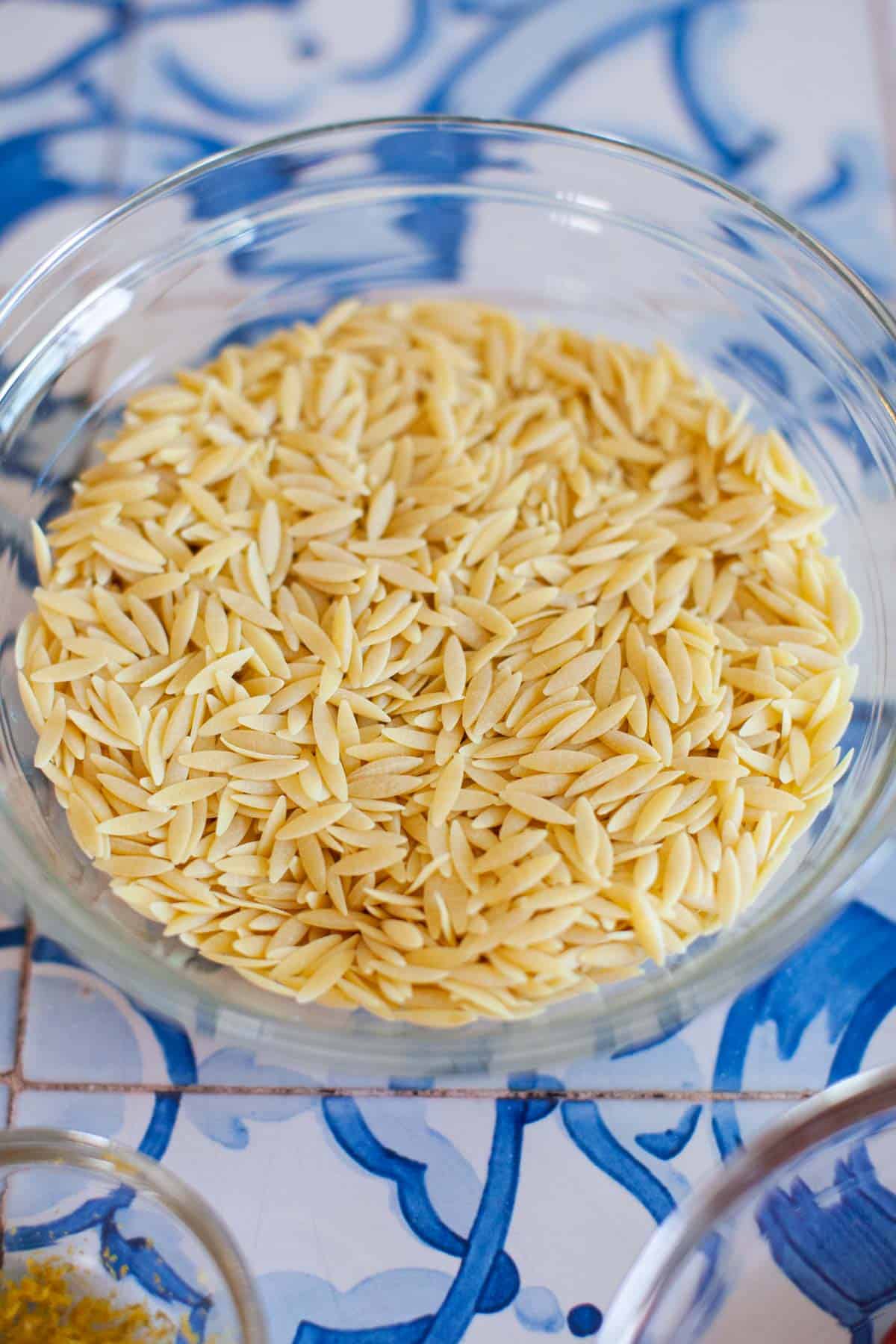 Dry orzo in a glass bowl.