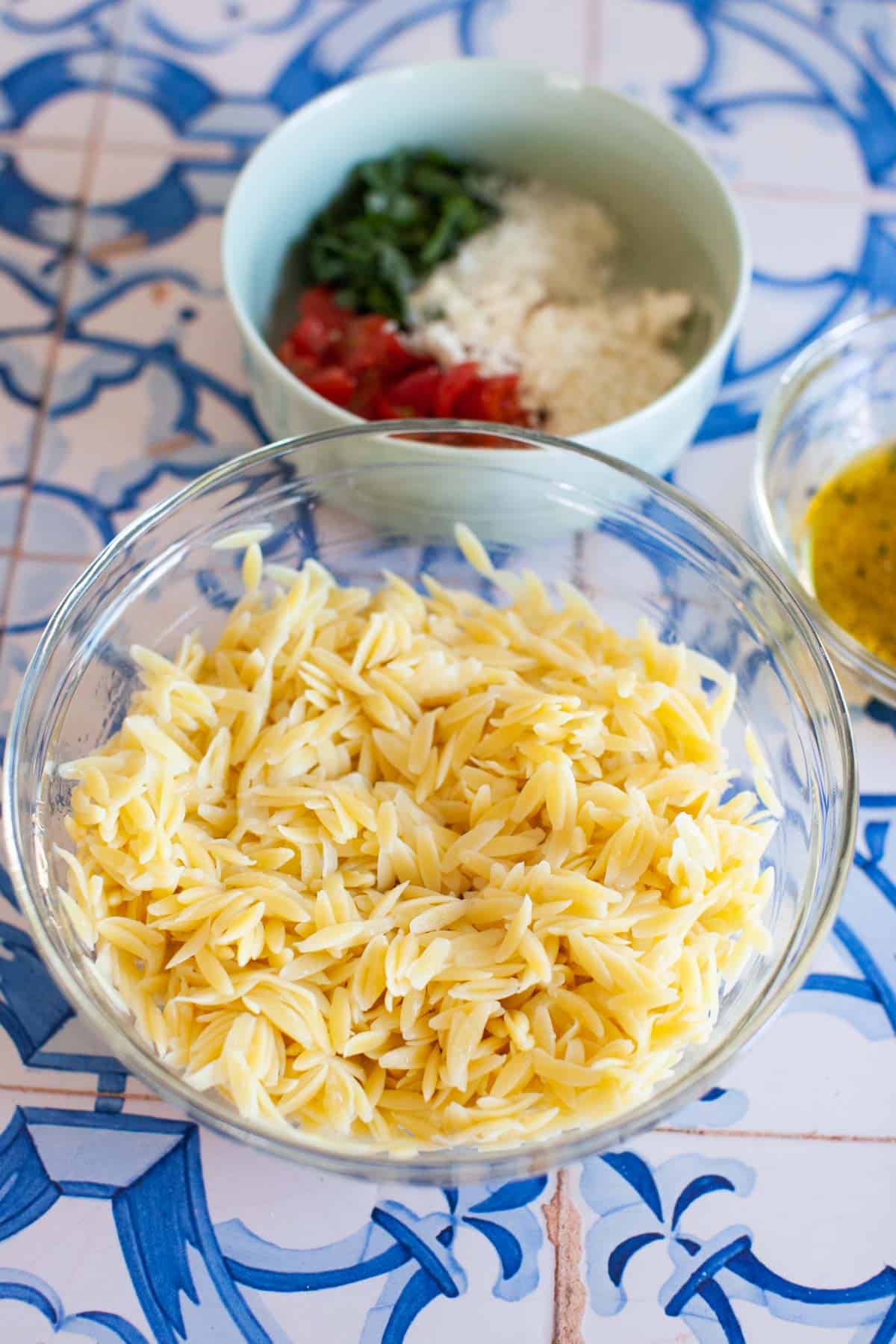 Cooked orzo pasta in glass bowl.