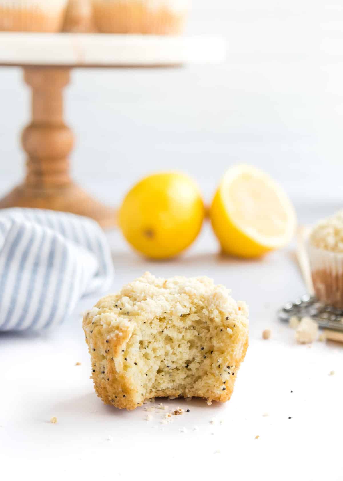 A lemon poppy seed muffin with a bite taken out of it on a countertop.