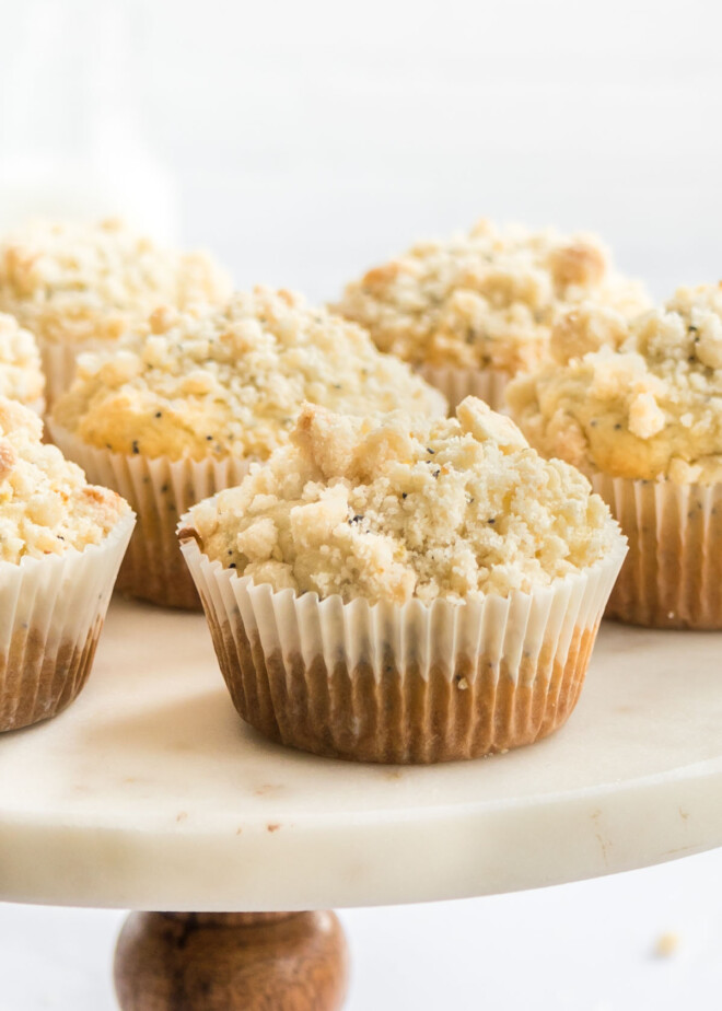 Close-up photo of lemon poppy seed muffins on a circular pedestal.
