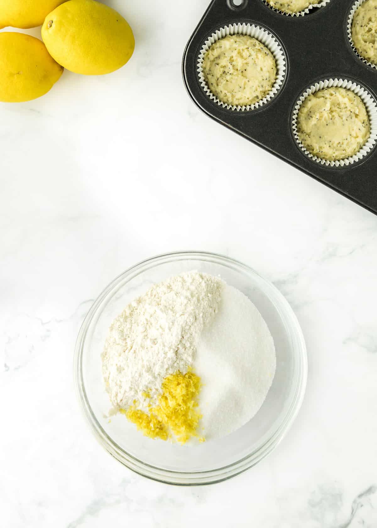 Flour, sugar and lemon zest for the crumble in a small glass mixing bowl.