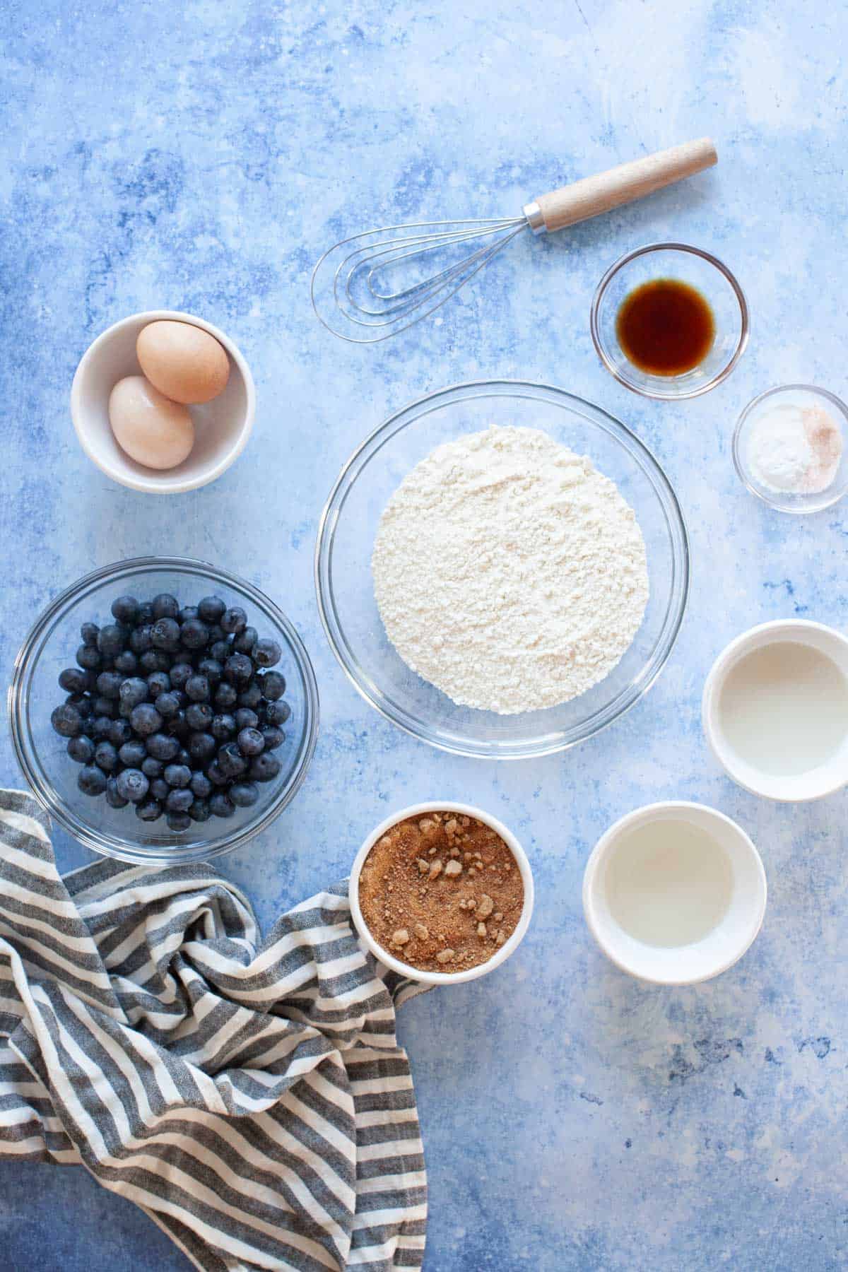 Blueberry bread ingredients in individual glass bowls.