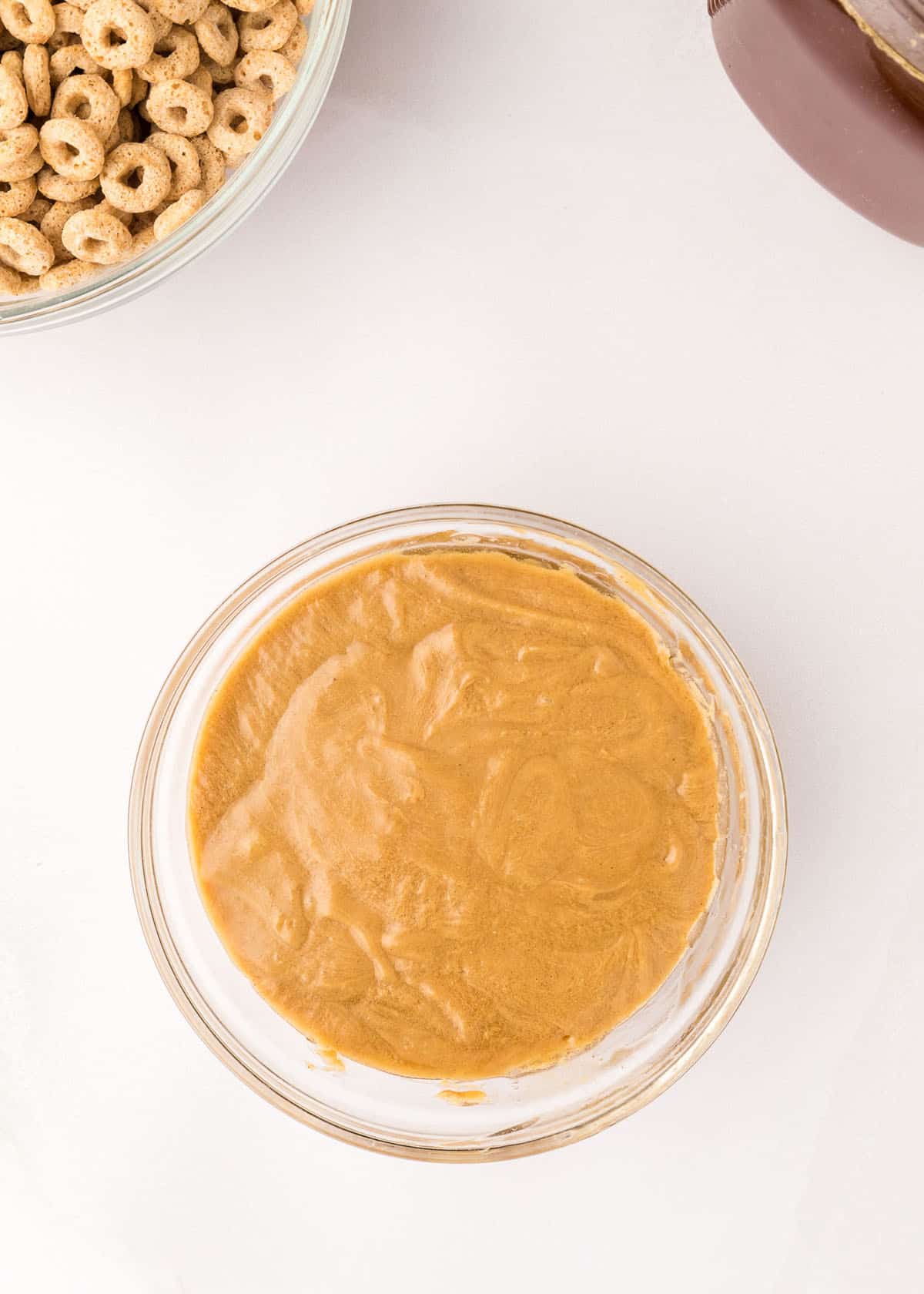 Honey and peanut butter mixed together in a glass mixing bowl.