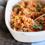 Mexican cauliflower rice being spooned out of serving dish.