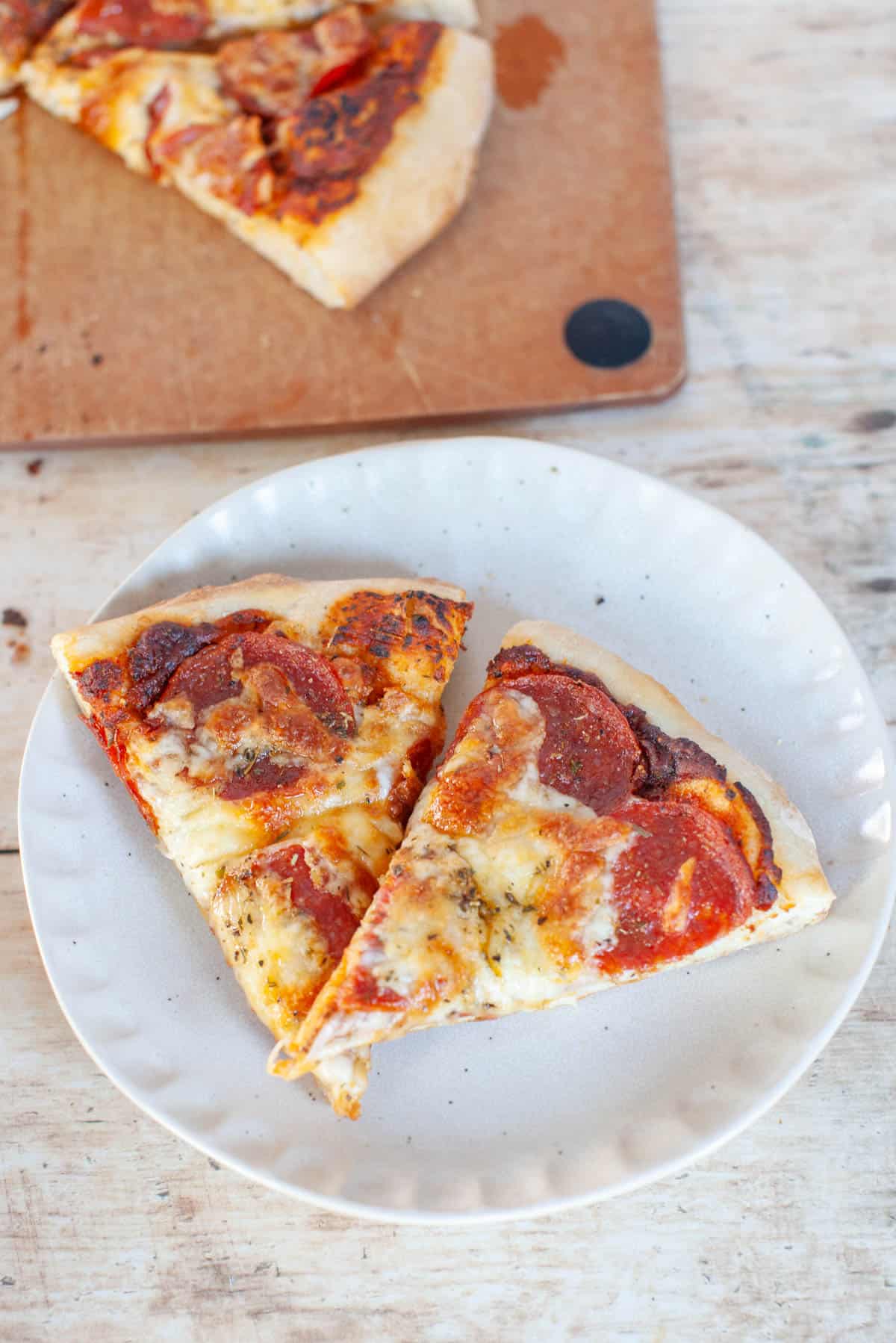 two slices of pizza on a white plate.