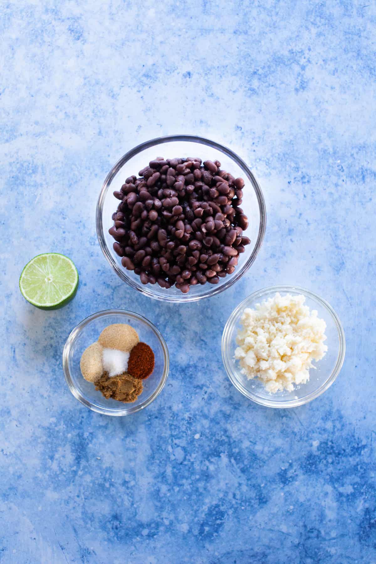 Refried black bean ingredients separated into small glass bowls.