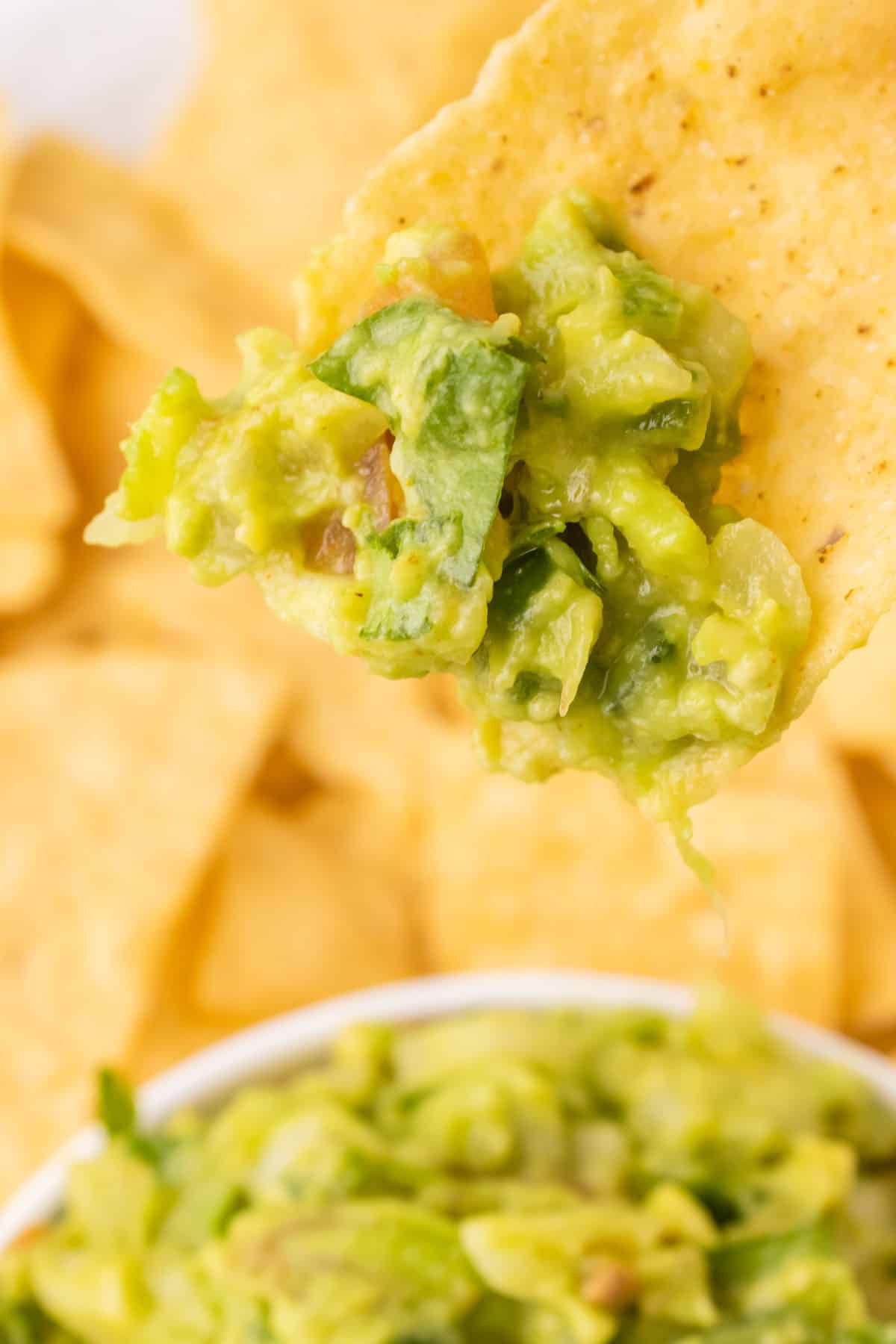 A tortilla chip dipped in the easy guacamole.