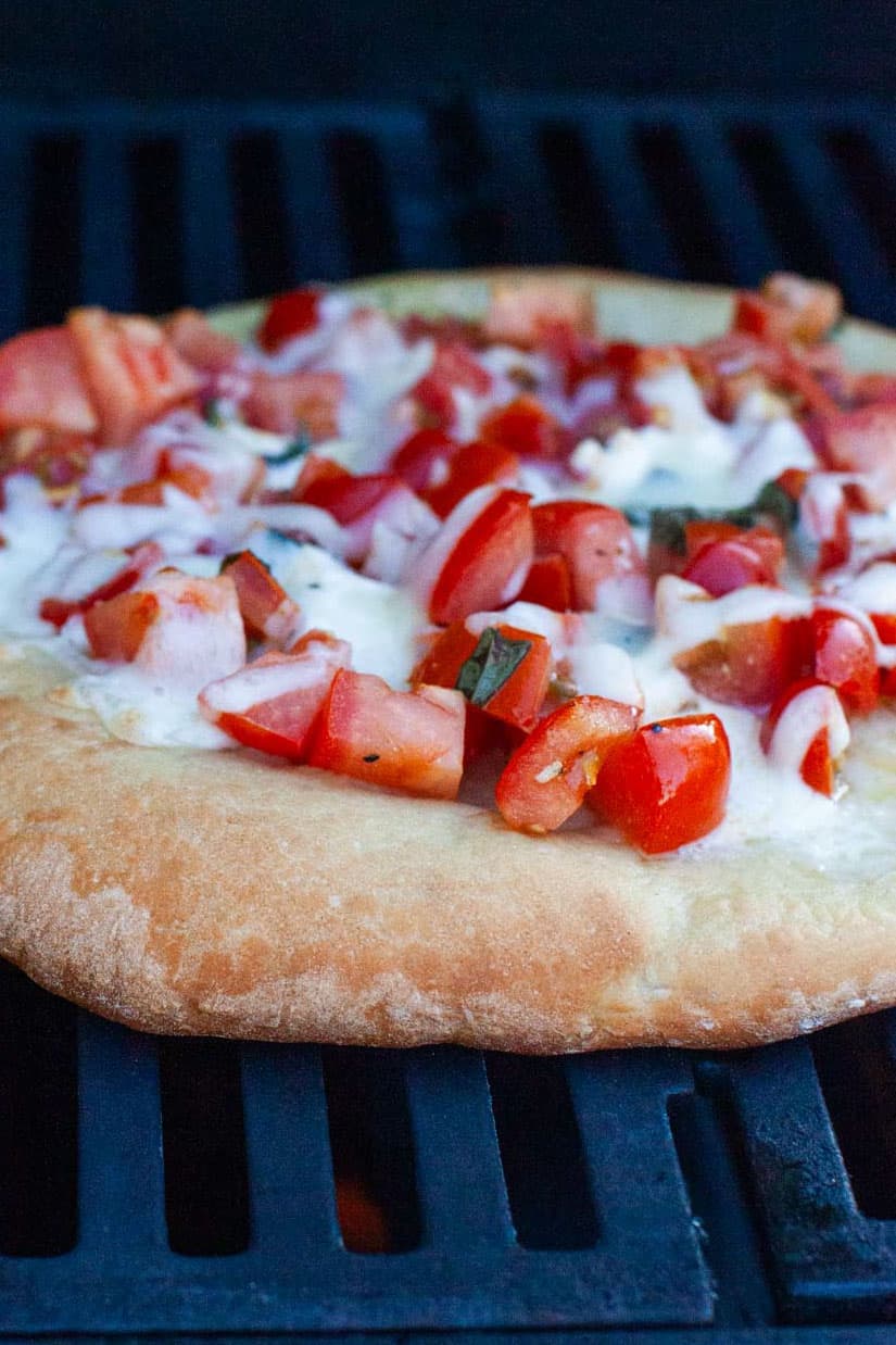 Fully cooked bruschetta pizza on the grill