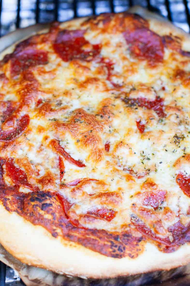 Overhead photo of Smoked Pizza with pepperoni and cheese on a grill.