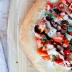 Thin crust pizza dough with bruschetta toppings and balsamic drizzle.