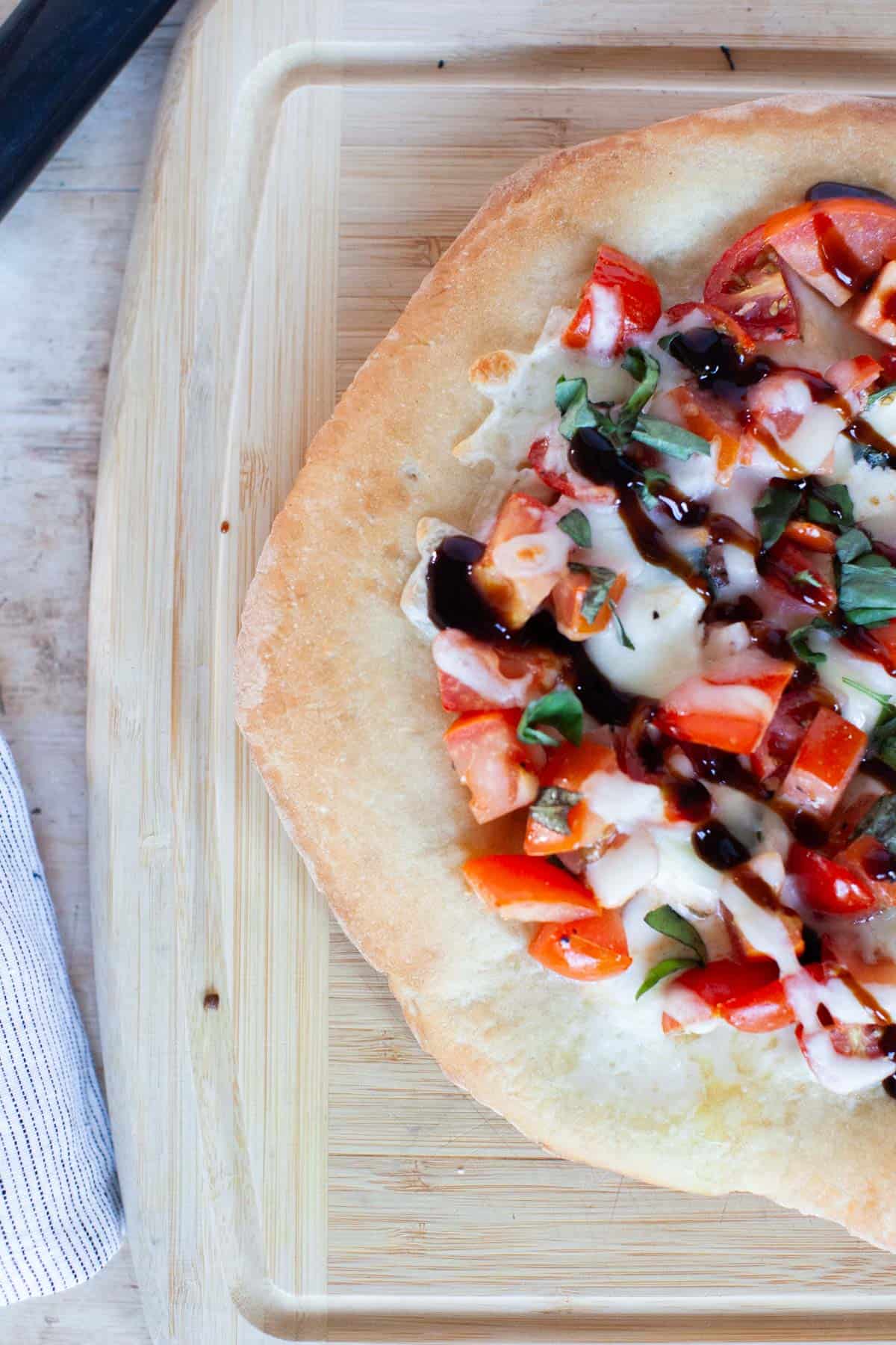 Thin crust pizza dough with bruschetta toppings and balsamic drizzle.