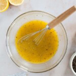 Dijon mustard, spices, honey, vinegar and lemon juice whisked together with a wooden handled flat whisk.