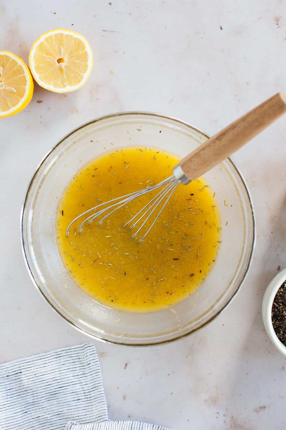 Dijon mustard, spices, honey, vinegar and lemon juice whisked together with a wooden handled flat whisk.