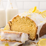 Slices of lemon loaf stacked on top of each other in front of the rest of the loaf.