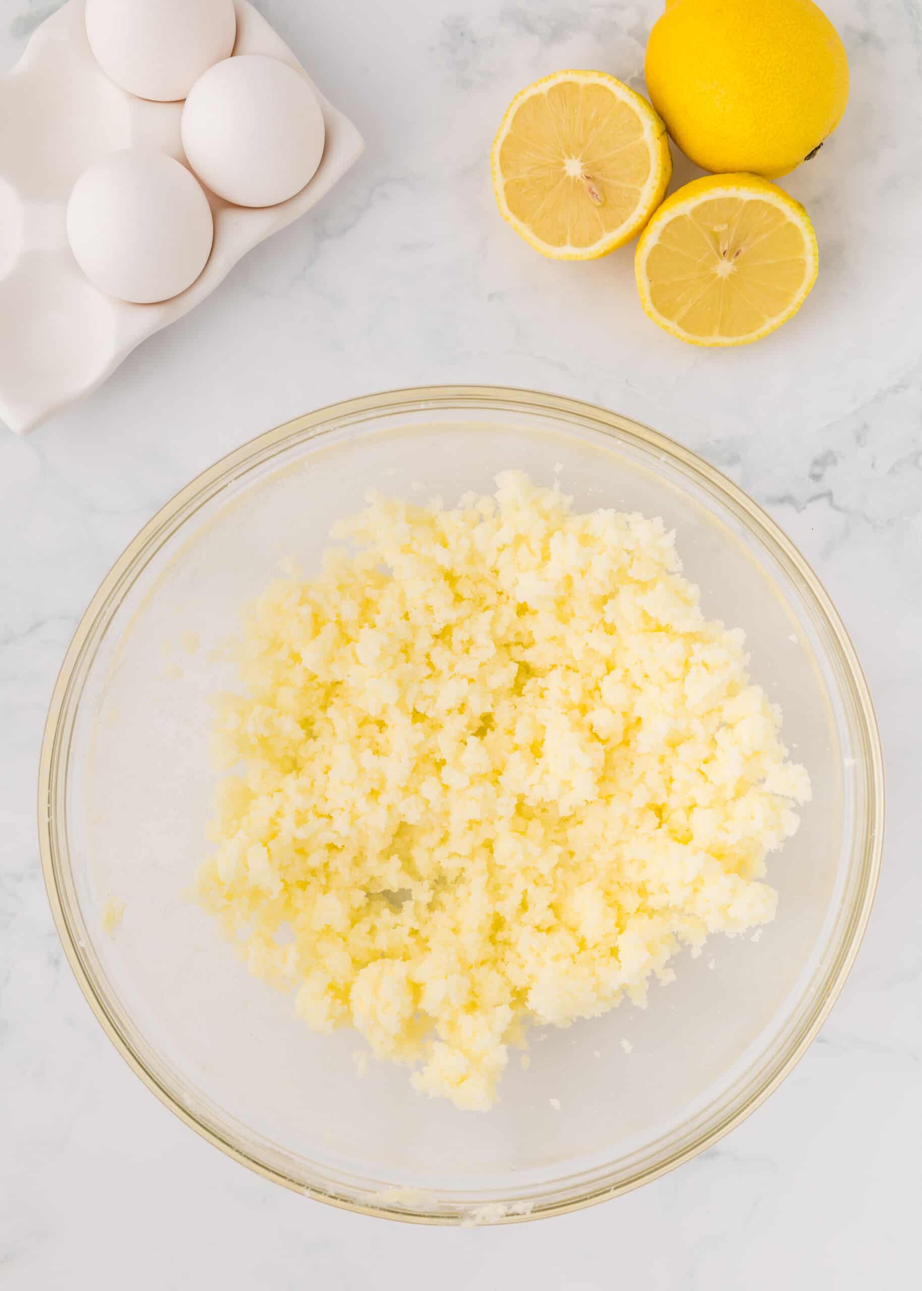 Butter and sugar beaten together in a glass mixing bowl.