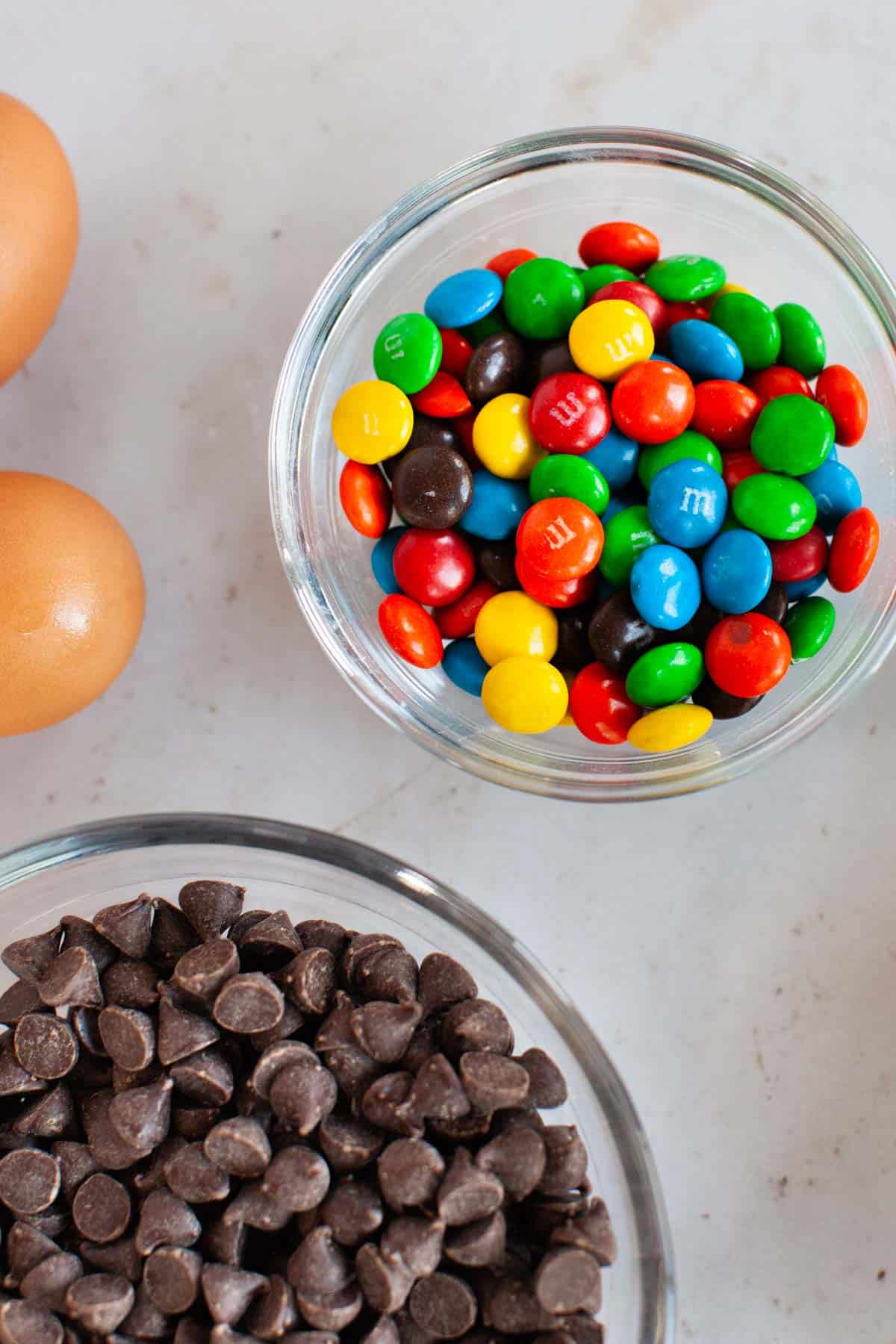 M&M's and chocolate chips in small glass bowls.