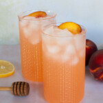 Two glasses of iced peach lemonade.