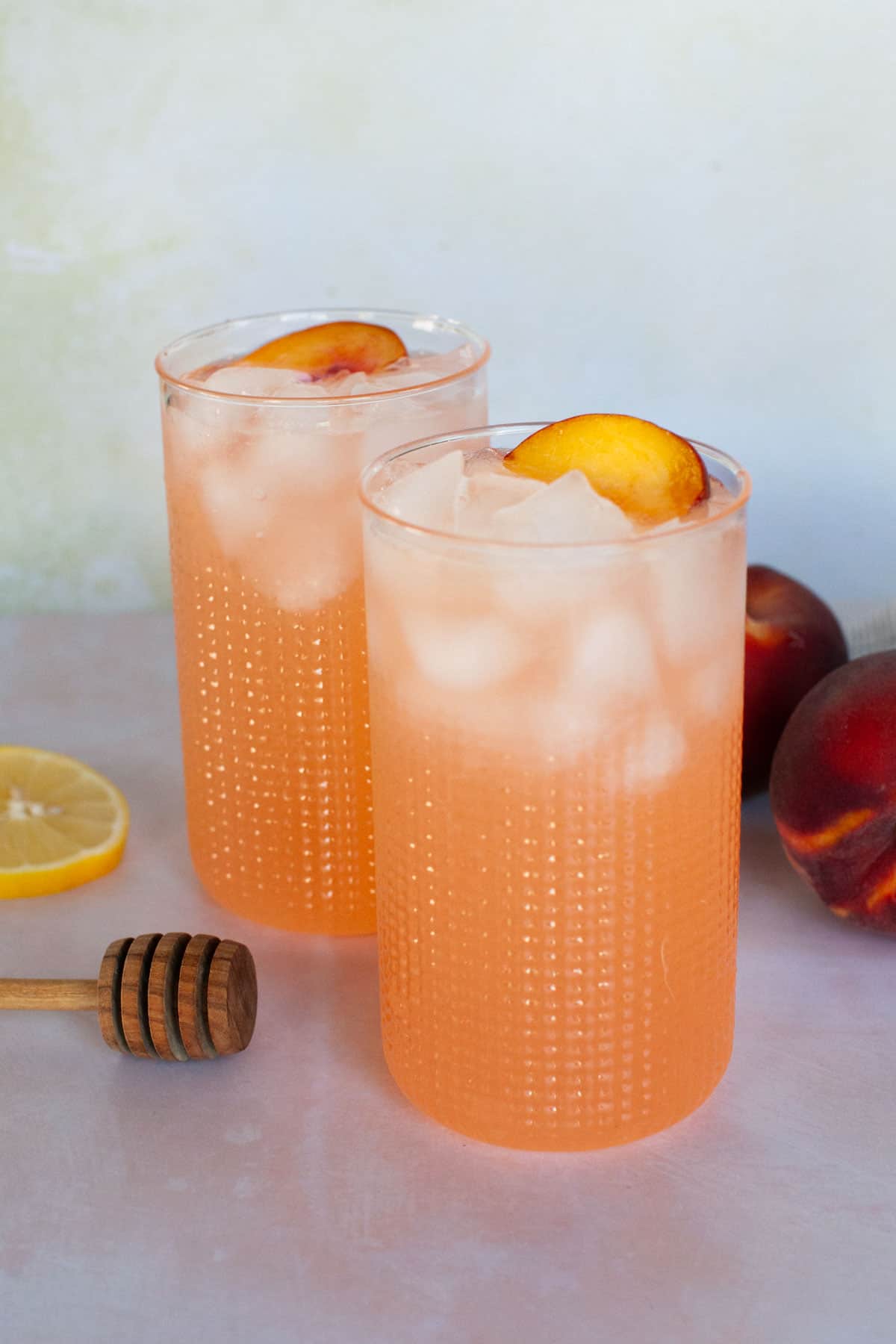 Two glasses of iced peach lemonade.