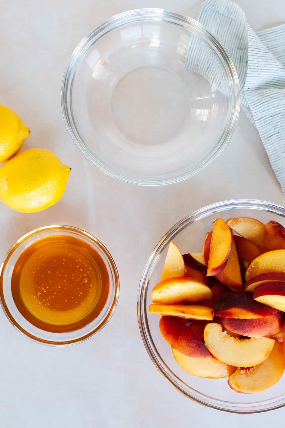 Ingredients for peach lemonade in separate bowls.