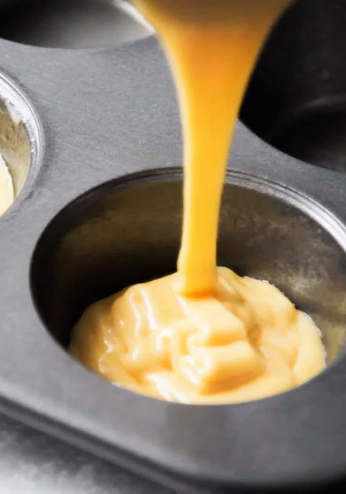 cake batter pouring into a muffin tin.