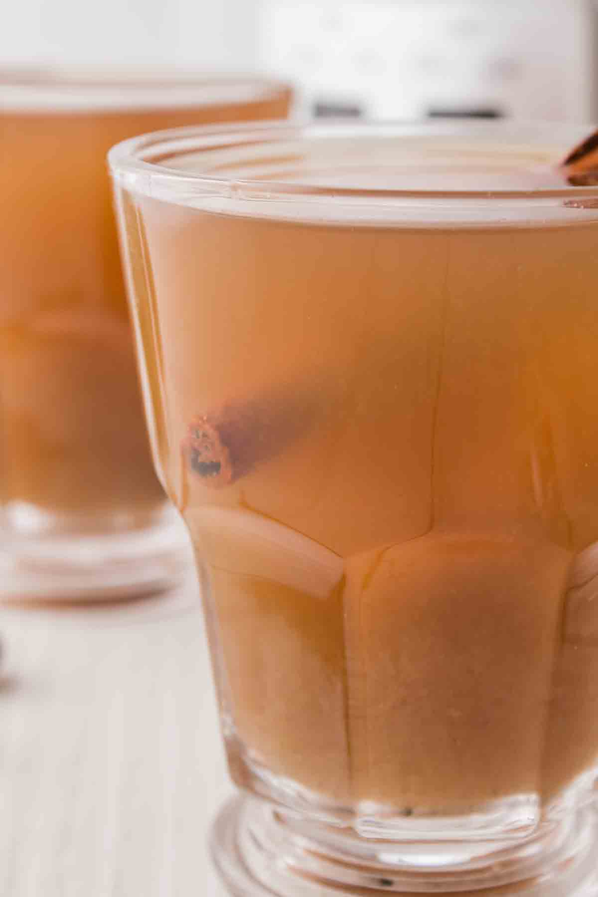 A close up shot of a mug full of spiced apple cider.