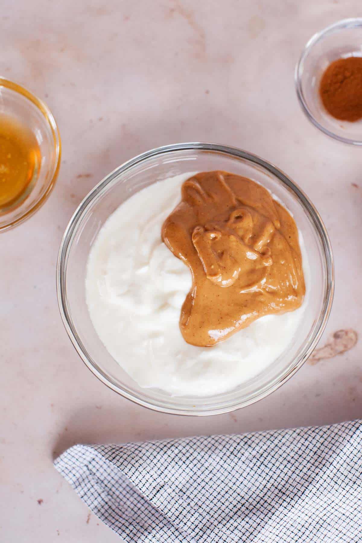 Yogurt and peanut butter in a glass bowl.