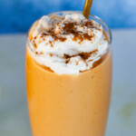 Pumpkin smoothie with cinnamon sprinkled on top of whipped cream.