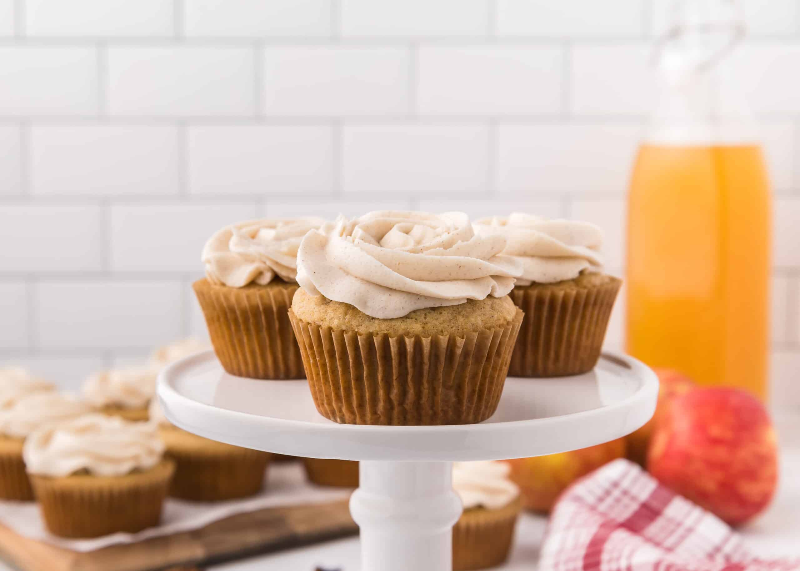 Apple spice cupcakes on a white cake stand.