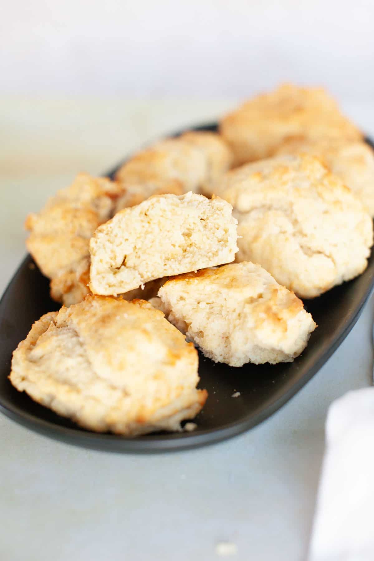 Easy drop biscuits split in half on a black plate.