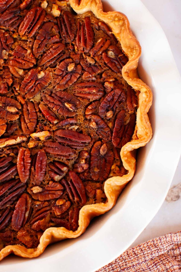 Pecan pie in a white pie dish.