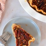 Pecan pie on a plate with a fork.