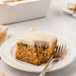 A slice of pumpkin cake on a plate with a fork.