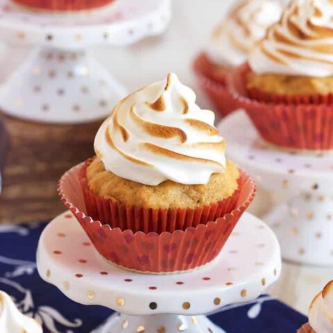 Meringue cupcakes on a blue and white polka dot tablecloth.