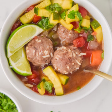 A bowl of Mexican meatball soup and vegetables.