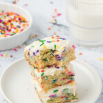 A stack of cake with sprinkles on a plate.