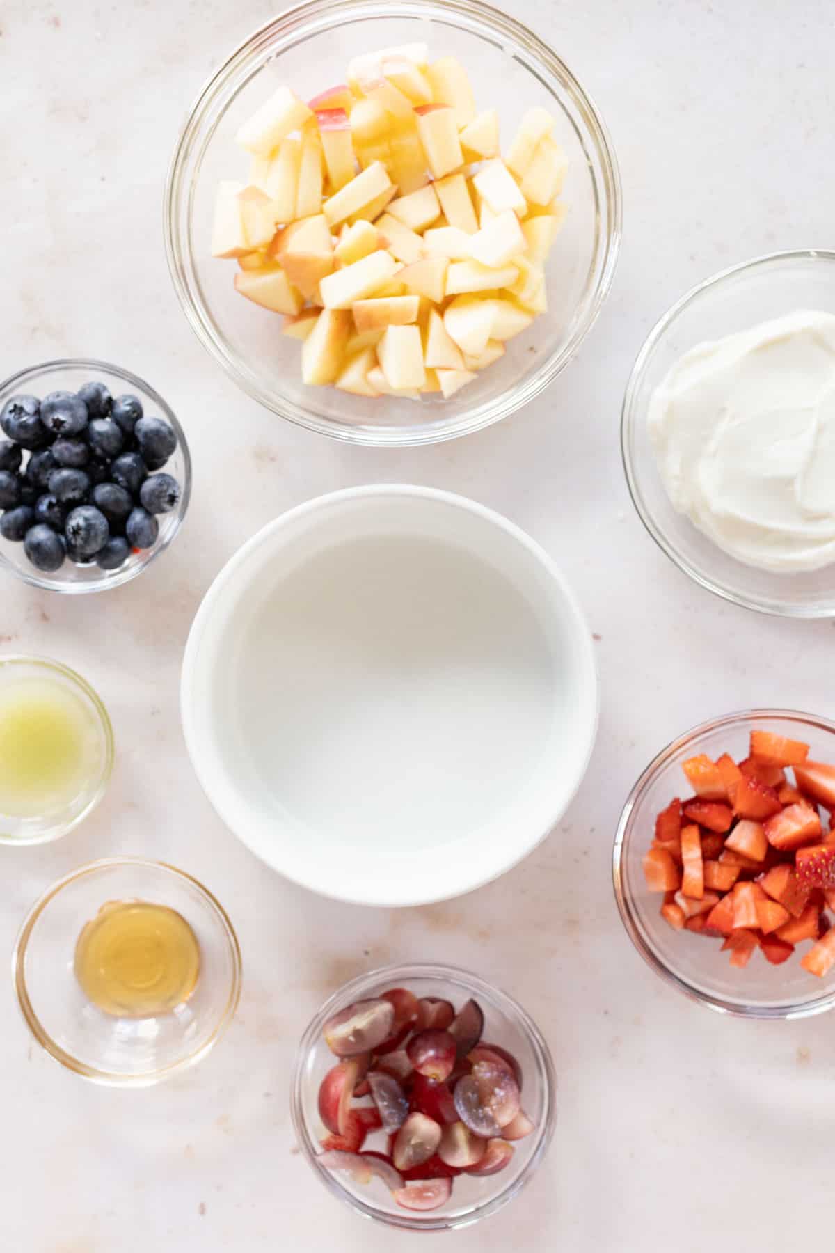 Assorted ingredients for creamy fruit salad.