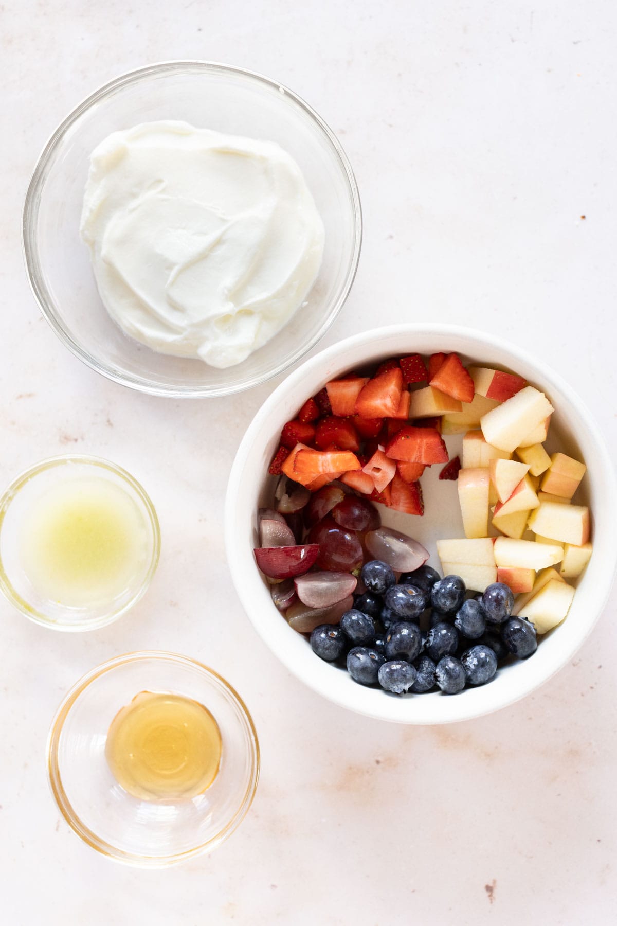 A bowl of fruit, yogurt, and other ingredients.