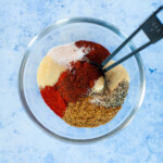 A bowl filled with ground beef taco spices and seasonings.